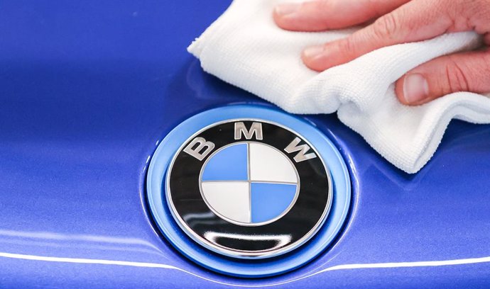 Archivo - FILED - 11 June 2020, Saxony, Leipzig: A BMW employee polishes the logo of a BMW i8 with a cloth. German carmarkers BMW and Mercedes-Benz are selling their joint car-sharing subsidiary Share Now to multinational automotive corporation Stellantis