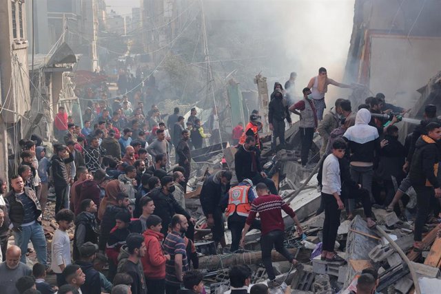 Archivo - Población de la Franja de Gaza se concentra frente a un edificio destruido por ataques de las Fuerzas de Defensa de Israel (FDI)