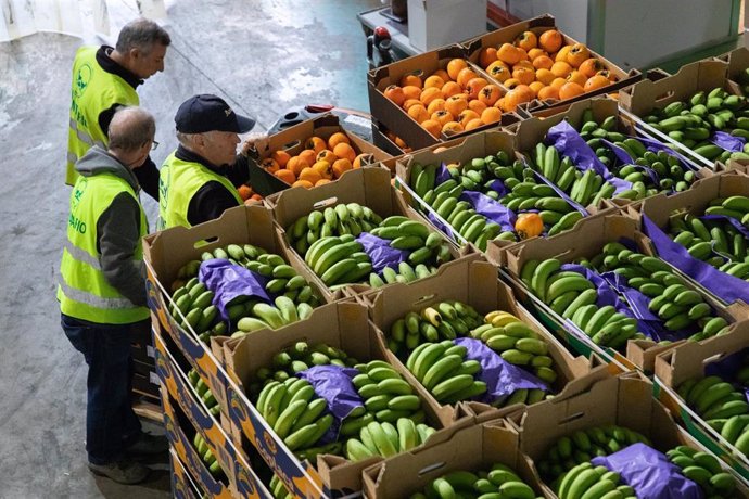 Archivo - Varios voluntarios trabajan en un banco de alimentos.