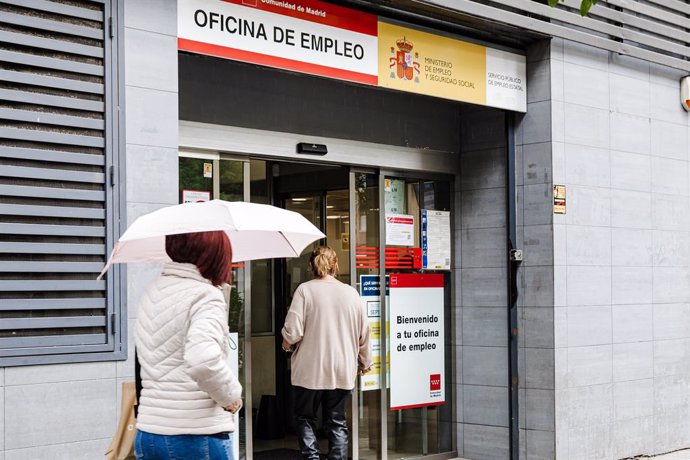Archivo - Una mujer con paraguas pasa por la oficina del paro de Paseo de las Acacias, a 26 de octubre de 2023, en Madrid (España). El paro subió en 92.700 personas en el tercer trimestre del año, lo que supone un 3,3% más que en el trimestre anterior y s