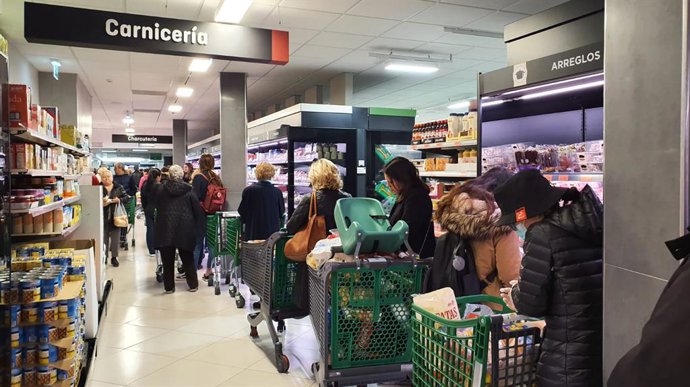 Archivo - Decenas de personas cargadas de provisiones esperan para poder pagar en un supermercado un día marcado por colas de gente deseosas de hacer acopio de alimentos y otros productos debido al avance del coronavirus en España, en Madrid (España), a
