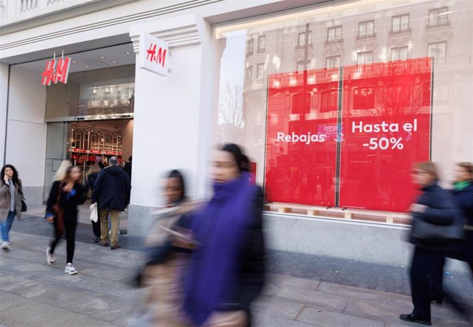 Archivo - Varias personas caminan frente a una tienda de H&M 