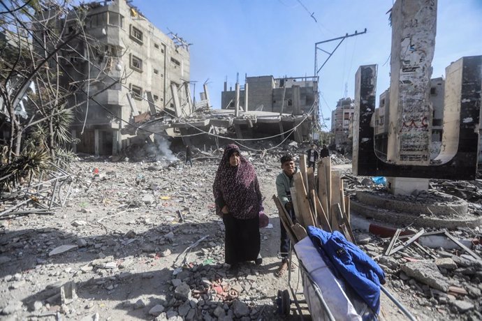 18 January 2024, Palestinian Territories, Nuseirat refugee camp: Palestinians salvage wood from the buildings destroyed by the Israeli bombing on the Nuseirat refugee camp, after the withdrawal of Israeli forces from the area. Photo: Mohammed Talatene/dpa