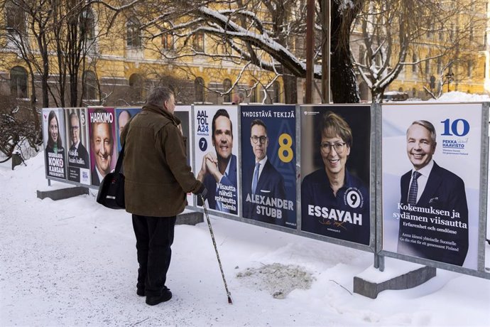 Ciudadano finlandés frente a carteles electorales de los candidatos a la Presidencia de Finlandia