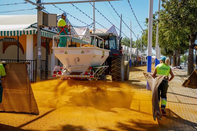 Archivo - Una cuadrilla de trabajadores cubriendo las calles de albero del recinto ferial donde se celebrará la Feria de Sevilla a 12 de abril del 2023 en Sevilla. (Foto de archivo).