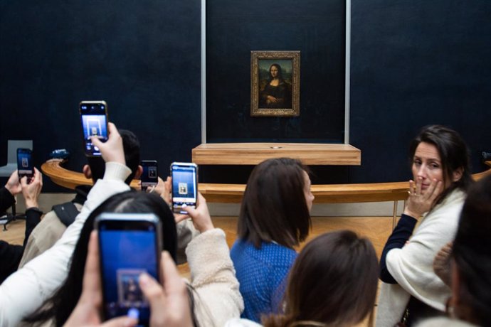 January 18, 2024: Paris, France. La Gioconda, also known as the Mona Lisa, a Renaissance work by Leonardo da Vinci, is observed by visitors of the Louvre Museum.