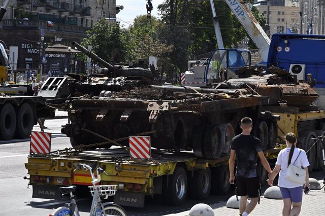 Archivo - Un grupo de personas pasea junto carro de combate del Ejército de Rusia destruido en la guerra con Ucrania expuesto en la capital ucraniana, Kiev (archivo)