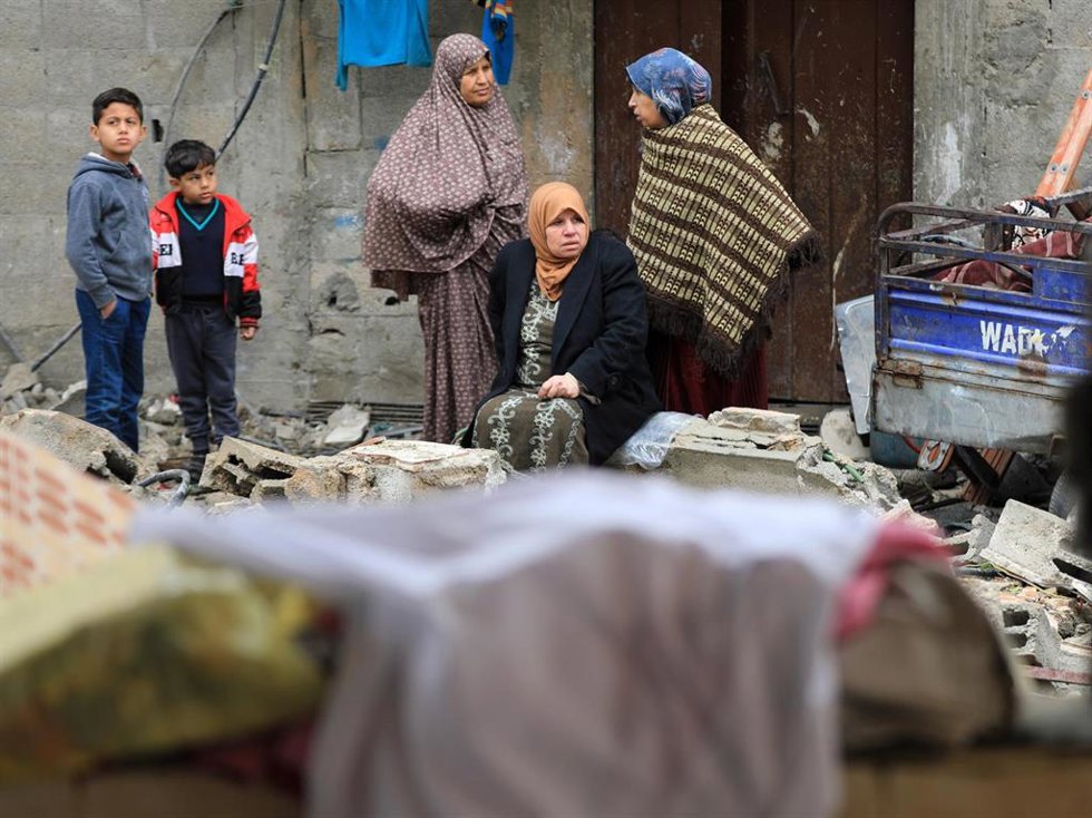 Un grupo de ciudadanos palestinos sobre los escombros de un edificio en Gaza.