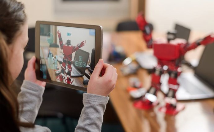 Una niña controla un robot mediante una tablet