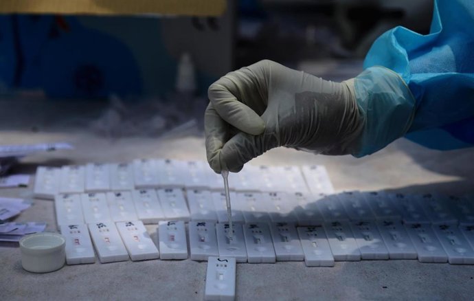 Archivo - 19 April 2021, India, New Delhi: A healthcare worker collects nasal swab samples for a Covid-19 rapid antigen testing along a street in New Delhi. New Delhi announced a one-week lockdown on Monday after a record surge in cases overburdened the I