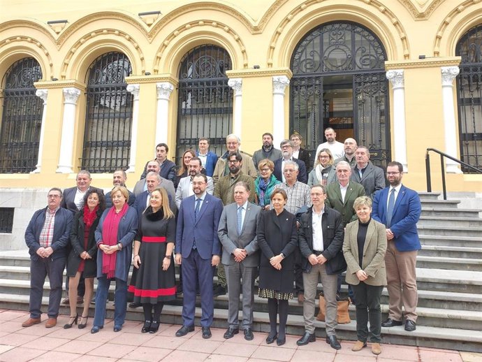 Foto de familia de la firma entre Principado y ayuntamientos del compromiso de adhesión a la primera fase de la red autonómica de 'Les Escuelines'.