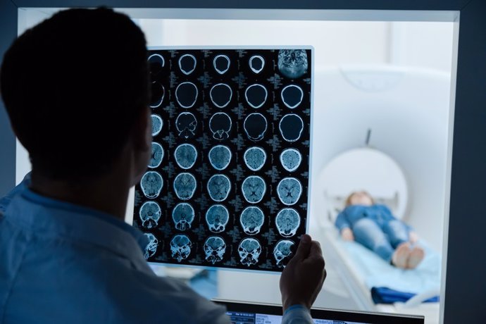 Archivo - Professional male oncologist looking at the MRI scan image.