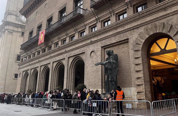 Zaragozanos en la fila de acceso para las visitas guiadas al Ayuntamiento.