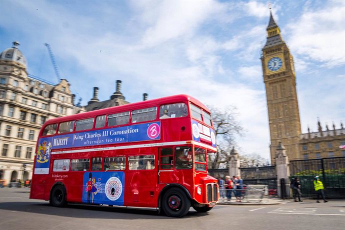 Archivo - 04 May 2023, United Kingdom, London: "King Charles Coronation" is written on a double-decker bus driving past Big Ben, ahead of the coronation of King Charles III and the the Queen Consort on May 6. Photo: Sina Schuldt/dpa