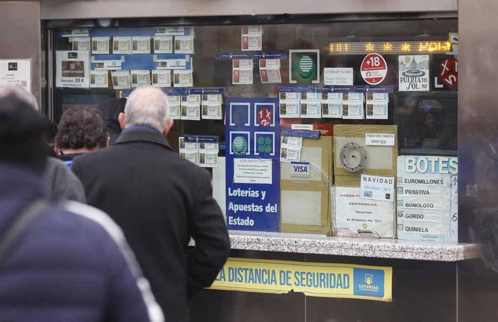 Archivo - Varias personas en una administración de lotería, archivo