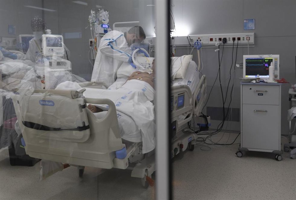 Archivo - Un sanitario alrededor de un paciente ingresado en la UCI.
