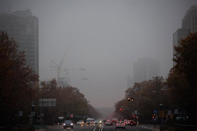 Archivo - Varios vehículos circulan por el Paseo de la Castellana con niebla, en Madrid, en una foto de archivo