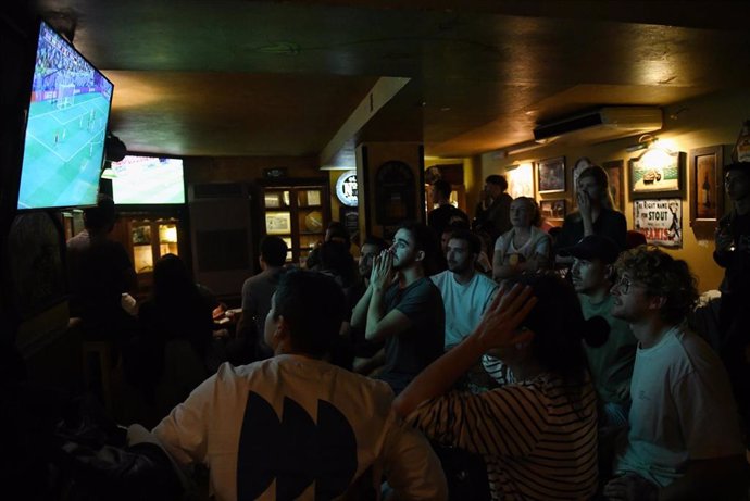 Archivo - Aficionados viendo un partido de fútbol en un bar de Madrid.
