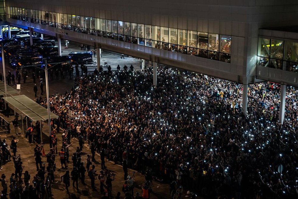 Archivo - Agentes de la Policía Nacional y Mossos de Esquadra, frente a la multitud que se concentra en el Aeropuerto de Barcelona- El Prat en protesta por la sentencia del Tribunal Supremo sobre el juicio del 'procés', en Barcelona (España), a 14 de oc
