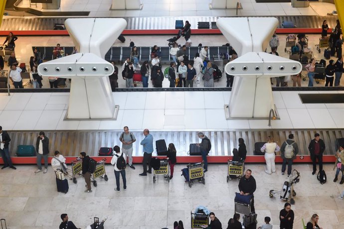 Pasajeros recogen sus maletas durante el último día de la huelga del servicio de handling de Iberia, en el aeropuerto Adolfo Suárez Madrid-Barajas, a 8 de enero de 2024, en Madrid (España).