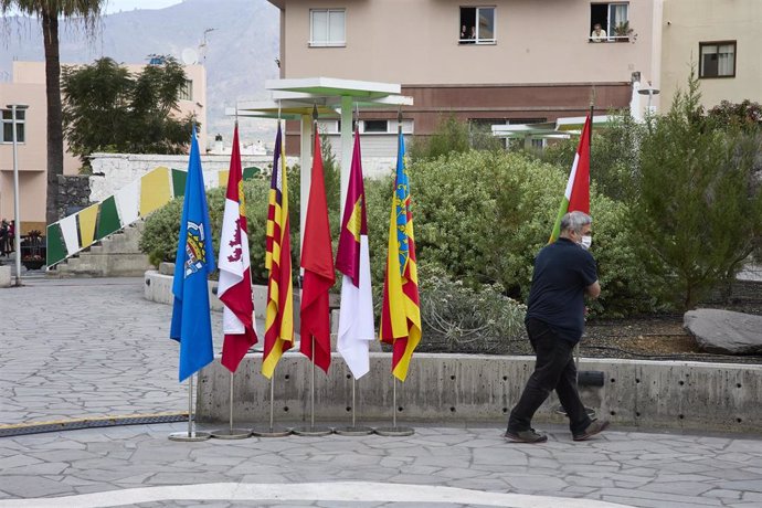 Archivo - Un operario retira las banderas de las comunidades autónomas, en la entrada del Museo Arqueológico Benahoarita, a 13 de marzo de 2022, en Los Llanos de Aridane, La Palma, Canarias (España). La reunión entre el jefe del Ejecutivo y todos los lí