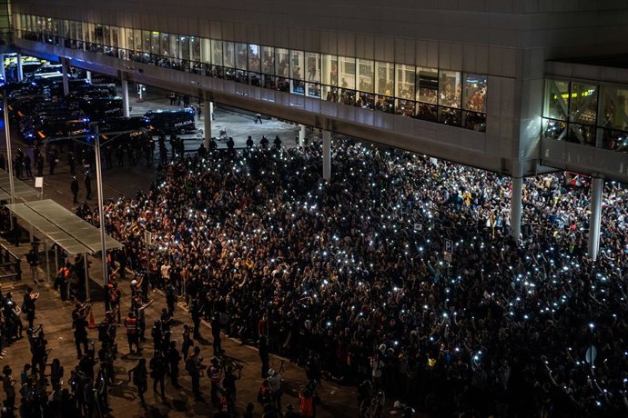Archivo - Agentes de la Policía Nacional y Mossos de Esquadra, frente a la multitud que se concentra en el Aeropuerto de Barcelona- El Prat en protesta por la sentencia del Tribunal Supremo sobre el juicio del 'procés', en Barcelona (España), a 14 de oc