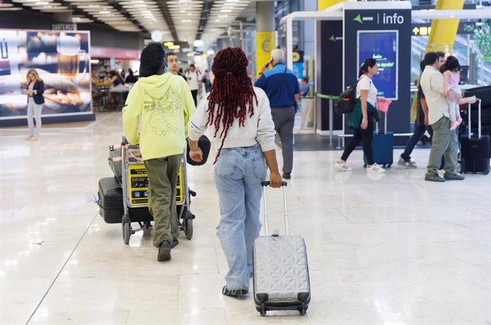 Archivo - Varias personas llegan a la Terminal 4 del aeropuerto de Adolfo Suárez Madrid-Barajas.