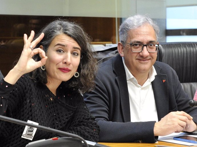 La portavoz de Unidas por Extremadura, Irene de Miguel, dibuja un cero con su mano, junto al diputado Joaquín Macías.