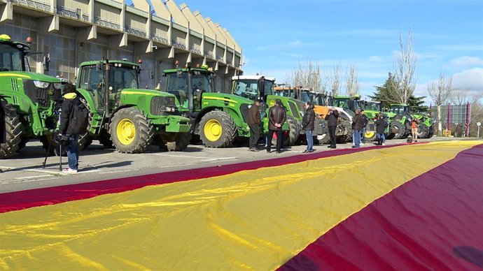 Tractores aparcados en la inmediaciones del Estadio José Zorilla de Valladolid junto a la bandera de España desplegada