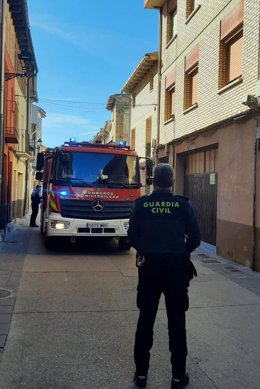 Un agente de la Guardia Civil y un camión de bomberos en el lugar del incendio.