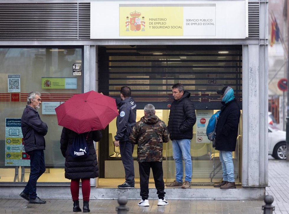 Archivo - Varias personas esperan para entrar en una oficina de empleo