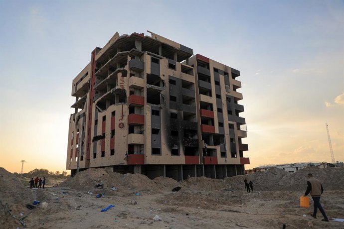 GAZA, Feb. 1, 2024  -- People walk past a damaged building in the southern Gaza Strip city of Khan Younis, on Feb. 1, 2024. The Palestinian death toll from the ongoing Israeli attacks in Gaza has reached 27,019, with 66,139 others wounded, the Gaza-base