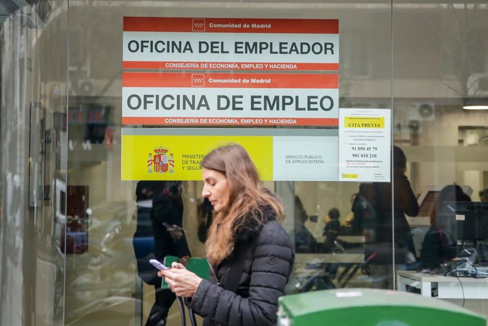 Archivo - Una mujer pasa junto a una oficina de empleo