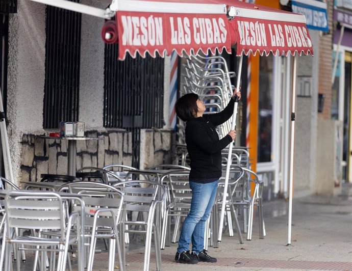 Una camarera levanta el toldo de un bar, a 12 de enero de 2024, en Madrid (España). El Ministerio de Trabajo ha acordado este viernes con CCOO y UGT subir el salario mínimo interprofesional (SMI) para 2024 un 5%, desde los 1.080 euros mensuales por catorc