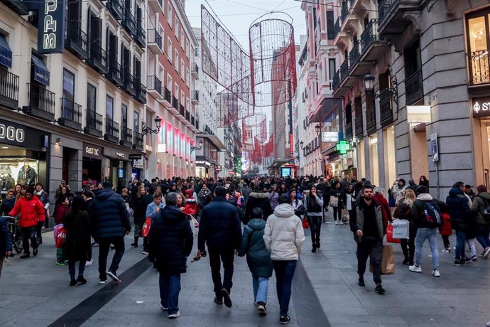 Archivo - Cientos de personas, con compras, en la calle comercial de Preciados, a 7 de enero de 2022, en Madrid (España). Aunque ya habían comenzado las rebajas online y los descuentos en algunos establecimientos, las primeras sin restricciones tras la 