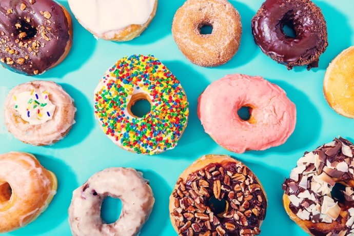 Archivo - Assorted donuts on pastel blue background Surtido de donuts sobre fondo azul pastel