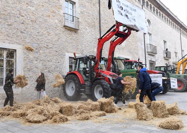 Agricultores protestan tirando paja ante la delegación de la Generalitat en Girona, a martes 6 de febrero de 2024.