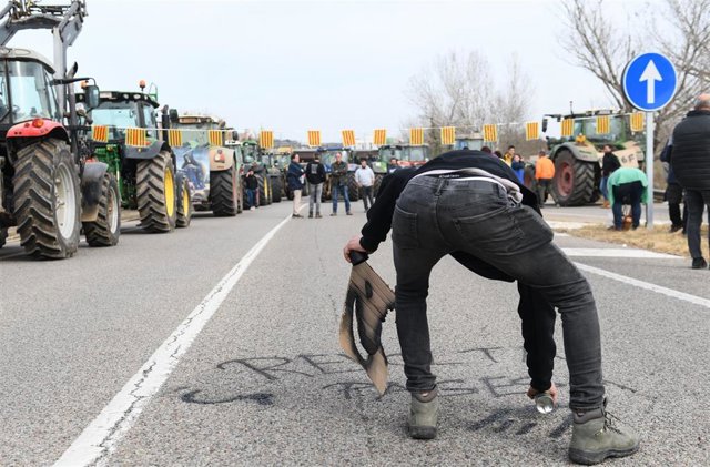 Agricultores pintan el suelo de la vía N-II a su paso por Medinyà (Girona) durante la interrupción de la circulación, a martes 6 de febrero de 2024