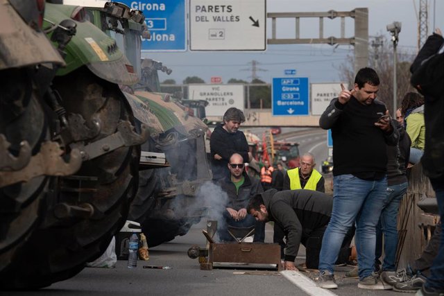 Varias personas entre los tractores que han cortado la carretera C-17, sentido sur, a la altura de Parets del Vallès, a 6 de febrero de 2024