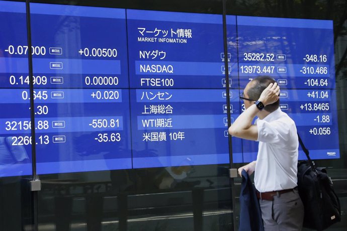 Archivo - 03 August 2023, Japan, Tokyo: A man walks past an electronic stock board showing Japan's Nikkei Stock Average, which trading closed down -548.41 points at 32159.28 in downtown Tokyo. Photo: Rodrigo Reyes Marin/ZUMA Press Wire/dpa