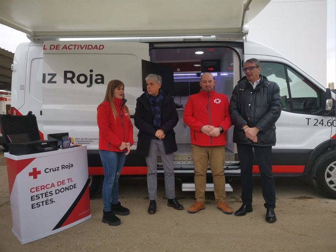 El delegado de la Junta en León y los responsables de Cruz Roja posan ante uno de los dos vehículos que prestarán servicios de carácter social en el medio rural de la provincia.
