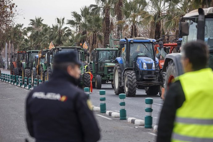 Un agent de Policia Nacional enfront d'una concentració de tractors en l'avinguda Germans Machado de València, d'ahir