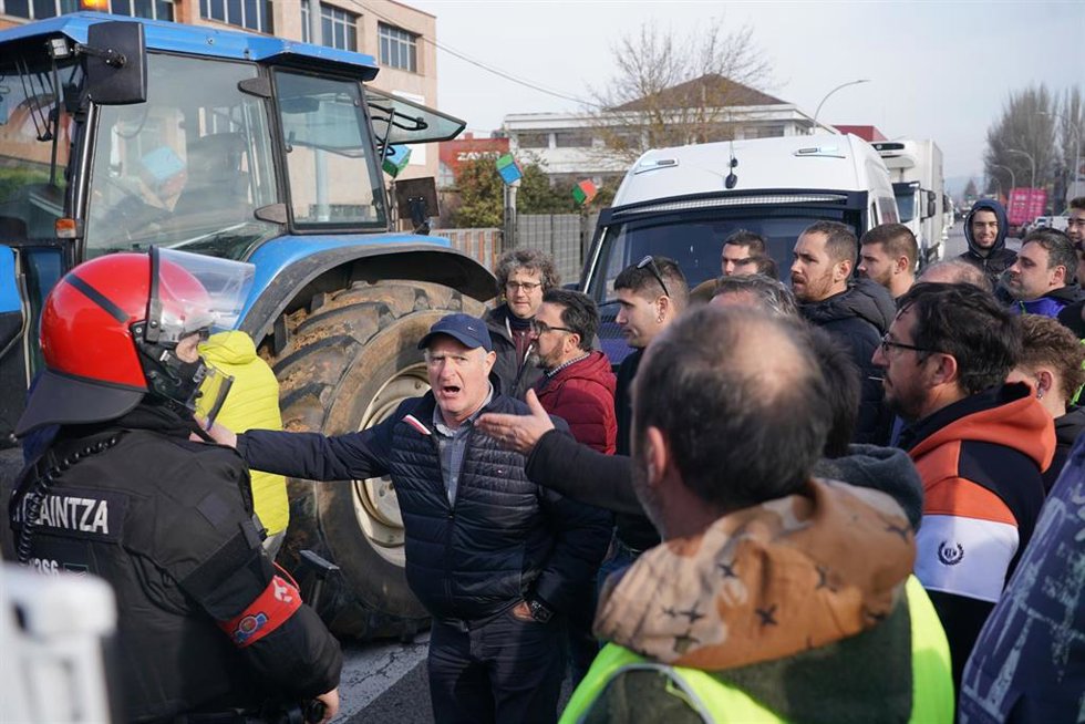 Un agente de la Ertzaintza junto a los agricultores en la segunda jornada de protestas, a 7 de febrero de 2024 en Vitoria-Gasteiz, Álava, Euskadi