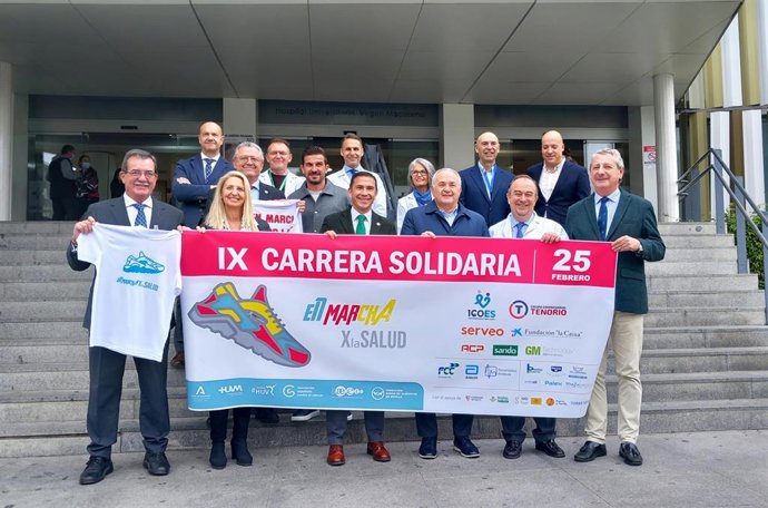 Representantes de las entidades colaboradoras de la carrera solidaria entre los hospitales Macarena y Virgen del Rocío posan, a las puertas del primero de los centros, para la tradicional  foto de familia.