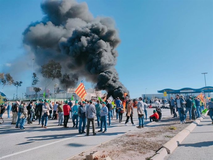 Agricultores cortan el acceso al Puerto de Castellón con barricada de neumáticos para denunciar la situación del sector