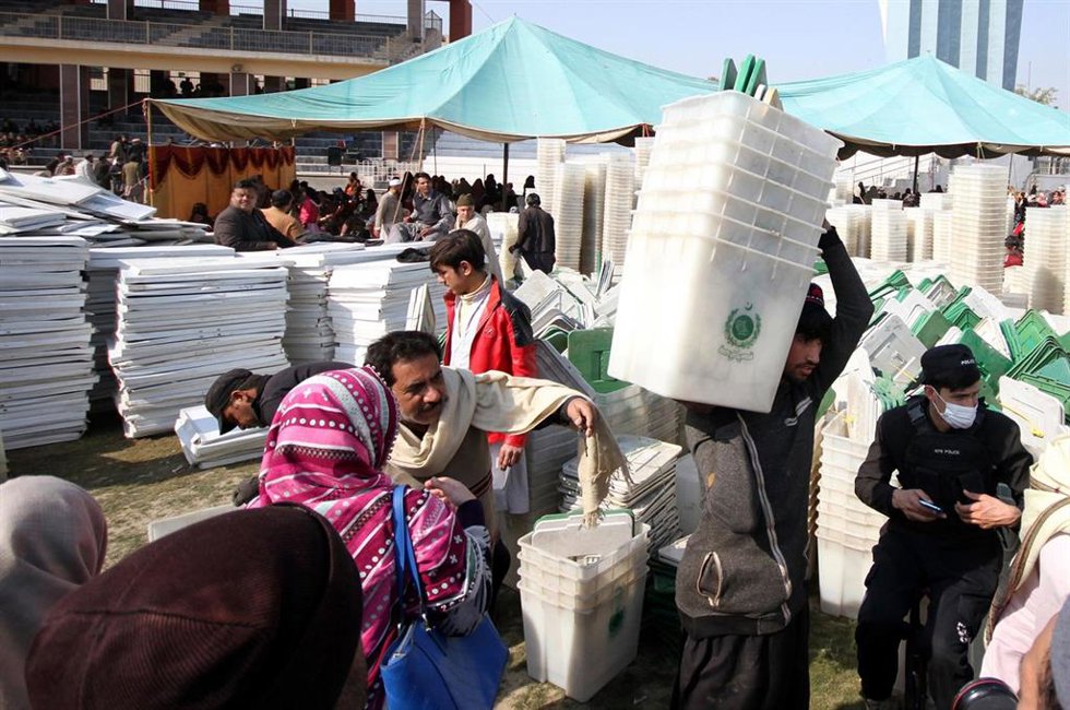 El personal electoral transporta urnas y material electoral para su colegio electoral un día antes de las Elecciones Generales de 2024 en Pakistán