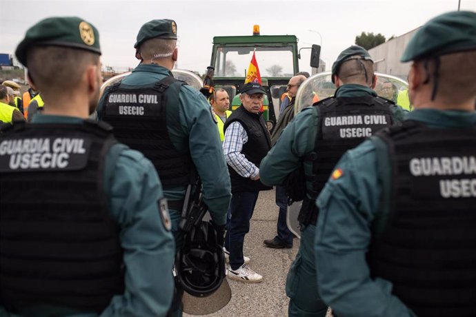 Agentes de Guardia Civil frente a los agricultores durante una concentración de tractores en Villarejo de Salvanés