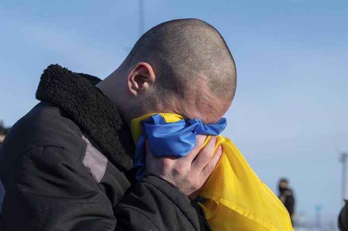 January 31, 2024, Bakhmut, Donetsk Oblast, Ukraine: A Ukrainian soldier weeps into a Ukraine flag after arriving back home following a POW exchange between Russia and Ukraine, January 31, 2024 in an undisclosed location. The exchange was the 50th return o
