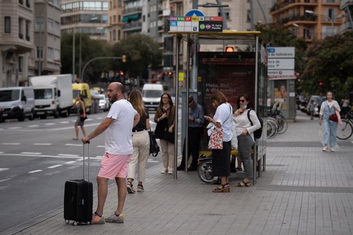 Archivo - Diverses persones esperen a la parada de l'autobús, a 23 de setembre de 2022, a Barcelona, Catalunya (Espanya)