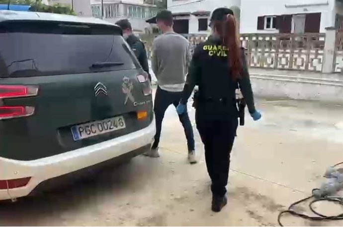 Agentes de la Guardia Civil acompañan a uno de los detenidos.